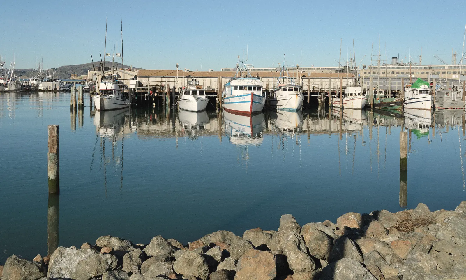 Photo of fishing boats and their reflections at Fisherman’s Wharf